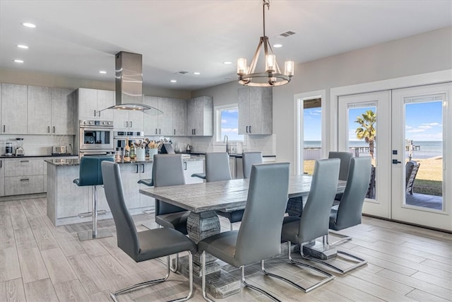 dining room featuring french doors, recessed lighting, visible vents, light wood-style flooring, and a chandelier