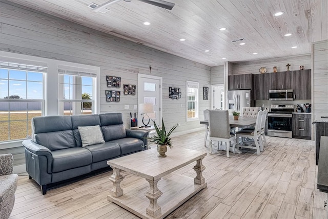 living area featuring light wood-style floors, recessed lighting, wooden ceiling, and wood walls