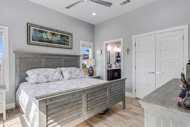 bedroom with light wood finished floors, ensuite bath, visible vents, and baseboards