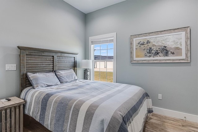 bedroom featuring baseboards and wood finished floors