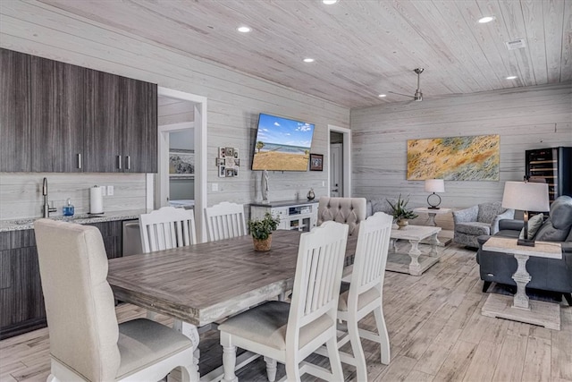 dining area featuring wooden walls, wooden ceiling, light wood-style flooring, and recessed lighting