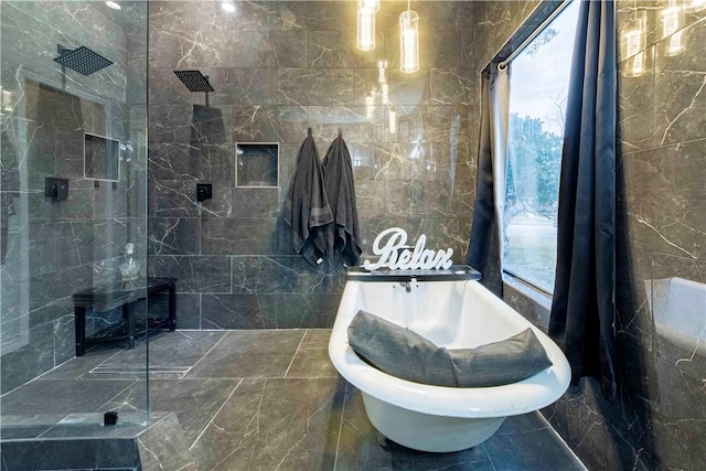 full bathroom with a freestanding bath, a walk in shower, and tile walls