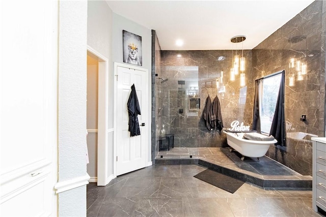 bathroom with marble finish floor, a freestanding tub, a shower stall, and vanity