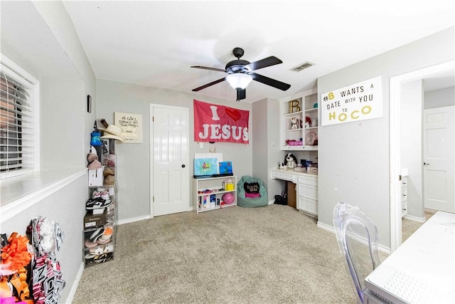 playroom with carpet, visible vents, a ceiling fan, built in study area, and baseboards