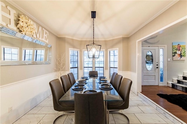 dining room with marble finish floor, a notable chandelier, crown molding, and stairway