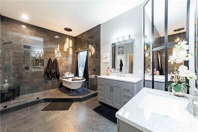 full bathroom with marble finish floor, two vanities, a tile shower, and a sink