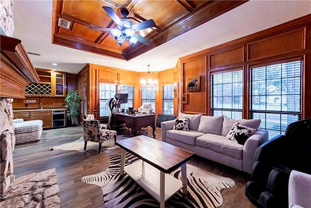 living area featuring visible vents, ornamental molding, wood ceiling, wood finished floors, and bar