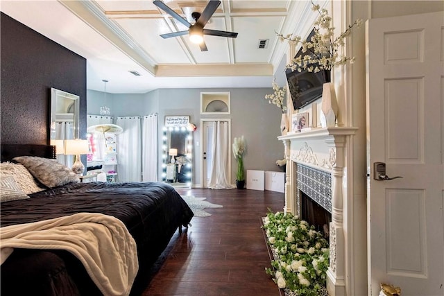 bedroom with visible vents, dark wood finished floors, crown molding, and a tile fireplace