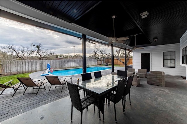 view of patio with outdoor dining area, a fenced backyard, ceiling fan, and a fenced in pool