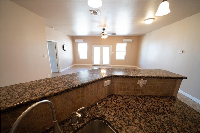 2033 Briarwood Dr, Corpus Christi, TX 78412 - kitchen featuring ceiling fan, dark stone countertops, a wall unit AC, open floor plan, and tile patterned flooring