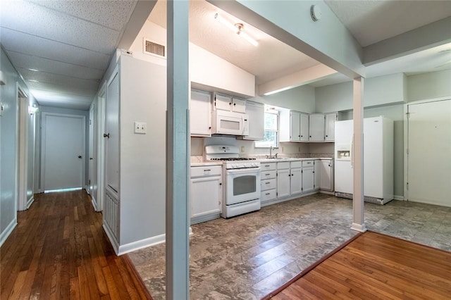 5933 Lucille Dr, Corpus Christi, TX 78412 - kitchen with white appliances, dark wood-style floors, light countertops, and white cabinetry