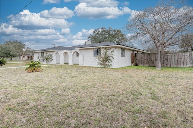 single story home featuring brick siding, fence, a chimney, and a front lawn