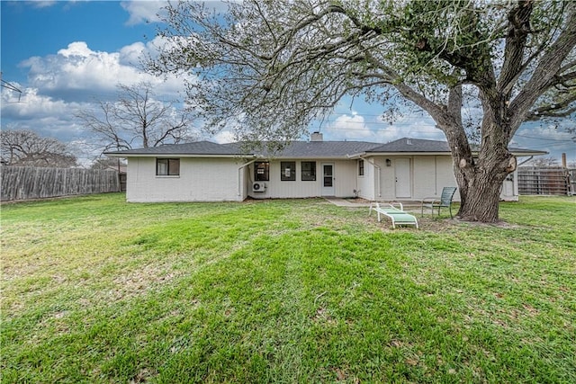 rear view of property featuring a chimney, fence, and a lawn