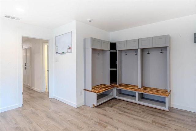 mudroom with light wood-type flooring, visible vents, and baseboards