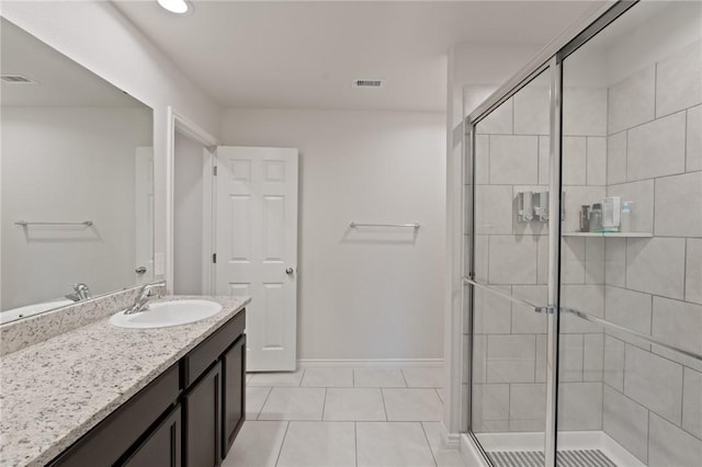 bathroom with tile patterned floors, vanity, and a shower with door