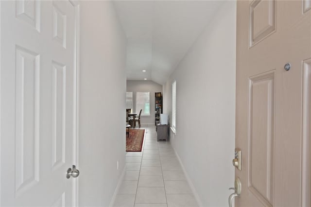 hall featuring lofted ceiling and light tile patterned floors