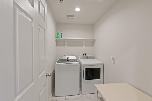 washroom featuring washer and clothes dryer and light tile patterned flooring