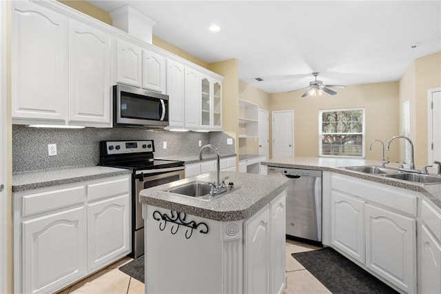 kitchen featuring sink, stainless steel appliances, an island with sink, and white cabinets