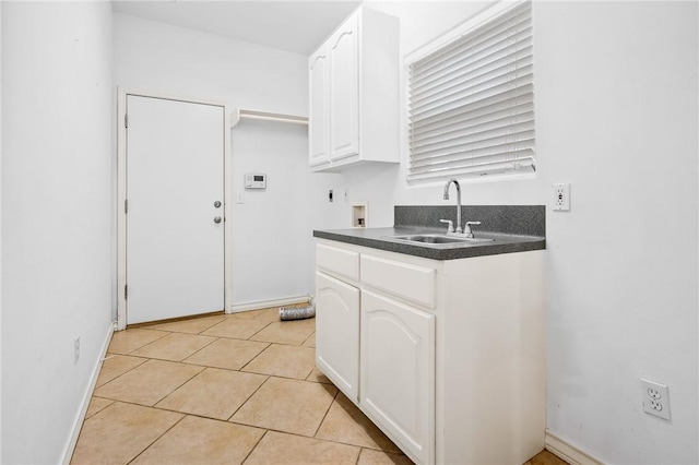 kitchen with sink, light tile patterned floors, and white cabinets