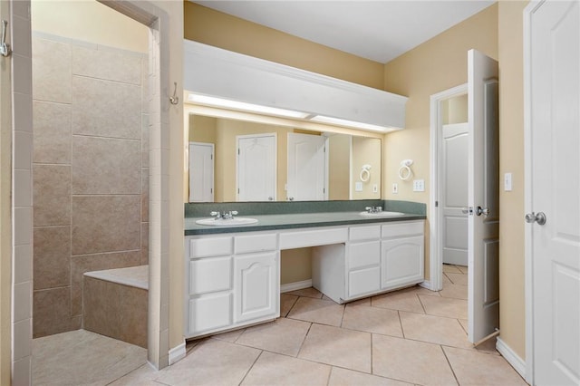 bathroom with tile patterned flooring, vanity, and tiled shower