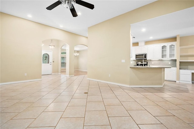 unfurnished living room featuring ceiling fan and light tile patterned floors