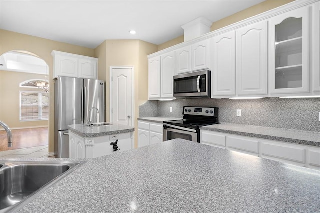 kitchen featuring appliances with stainless steel finishes, sink, white cabinets, and decorative backsplash