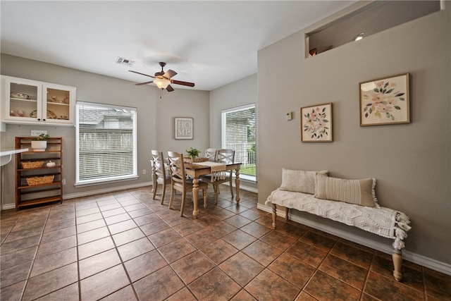 dining space featuring dark tile patterned floors and ceiling fan