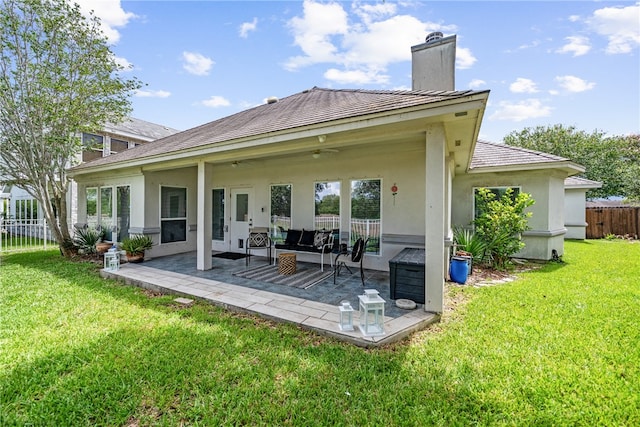 back of property with a patio, a yard, and an outdoor living space