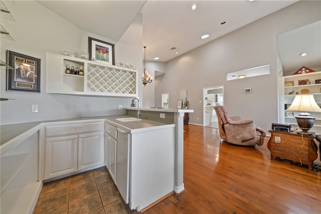 kitchen featuring white cabinets, sink, dark wood-type flooring, and kitchen peninsula