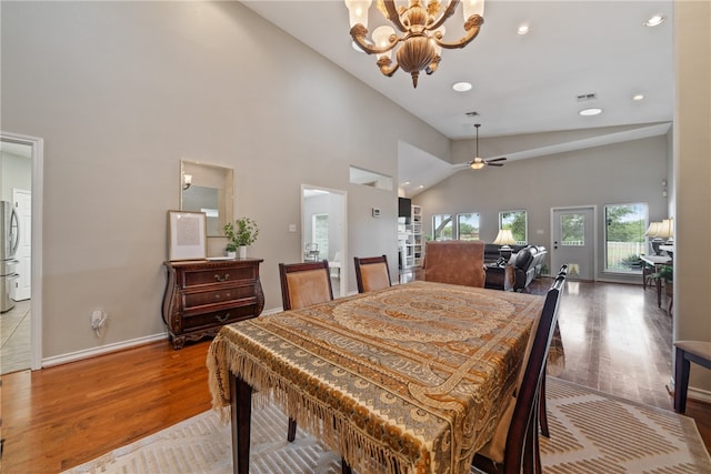 dining room featuring high vaulted ceiling, ceiling fan with notable chandelier, and hardwood / wood-style flooring