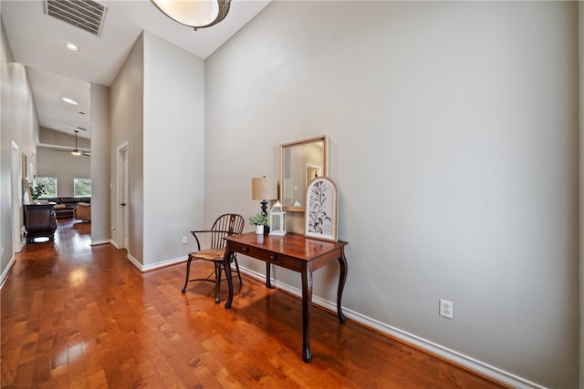 hallway with a high ceiling and hardwood / wood-style flooring