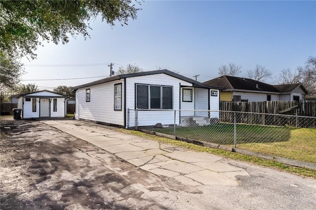 view of front facade with a front lawn, concrete driveway, and fence private yard