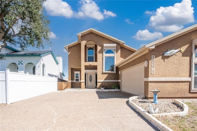 view of front facade with a garage, aphalt driveway, fence, and stucco siding