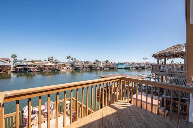 wooden terrace with a residential view and a water view