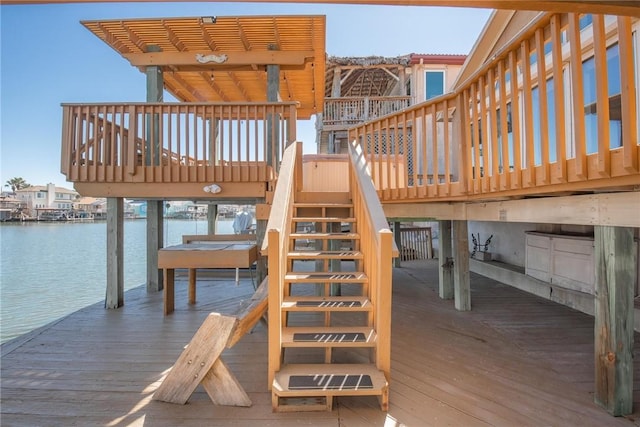 view of jungle gym featuring a water view, stairs, and a dock