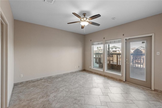 empty room with ceiling fan, visible vents, and baseboards