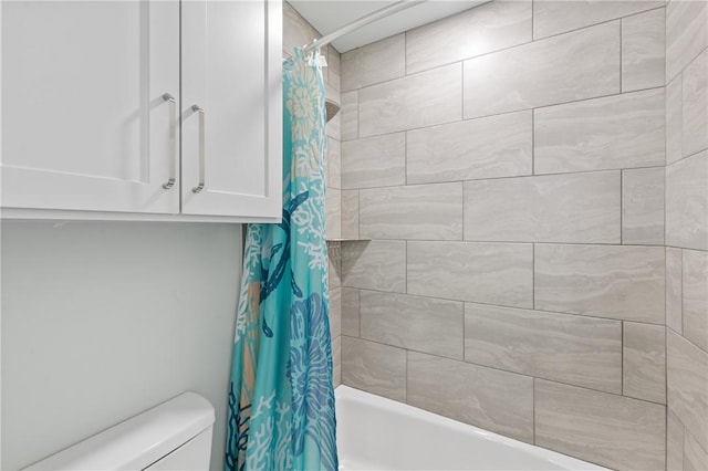 bathroom featuring shower / tub combo and toilet