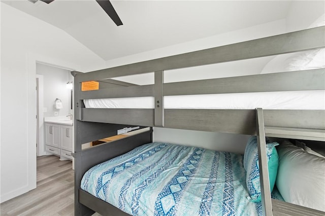 bedroom with ceiling fan, sink, vaulted ceiling, and hardwood / wood-style floors