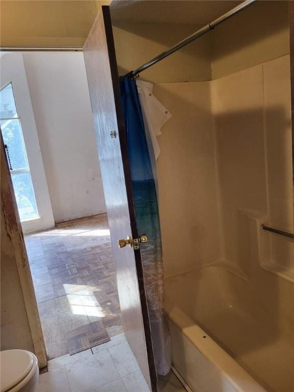 bathroom with a shower with shower curtain and toilet