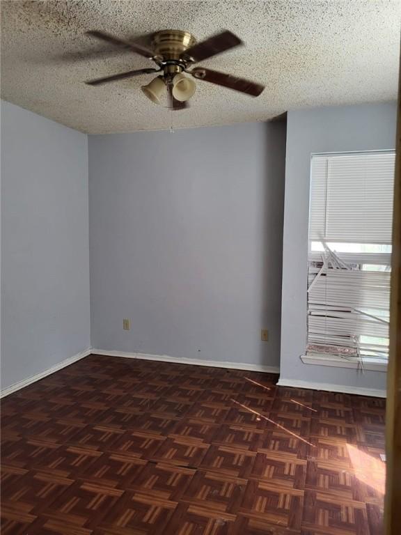 spare room with dark parquet flooring and a textured ceiling