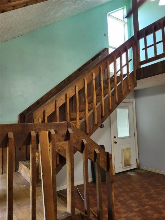 stairs with parquet flooring and a high ceiling