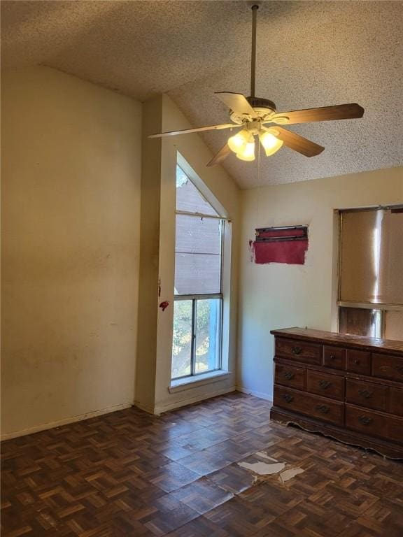 unfurnished bedroom featuring ceiling fan, lofted ceiling, a textured ceiling, and dark parquet floors