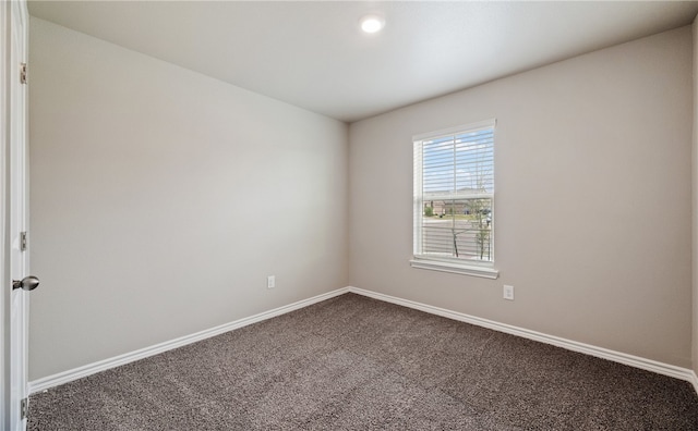 carpeted spare room featuring baseboards