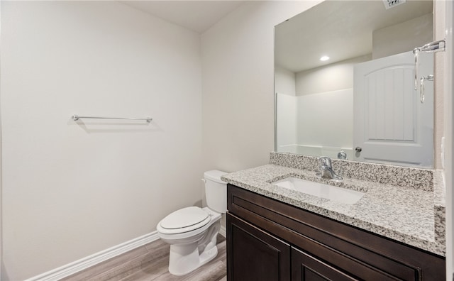 full bath featuring baseboards, toilet, wood finished floors, walk in shower, and vanity