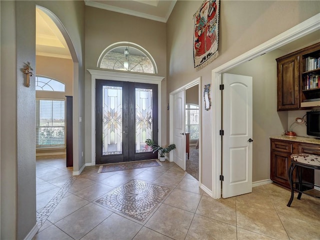 foyer entrance featuring light tile patterned floors, baseboards, and ornamental molding