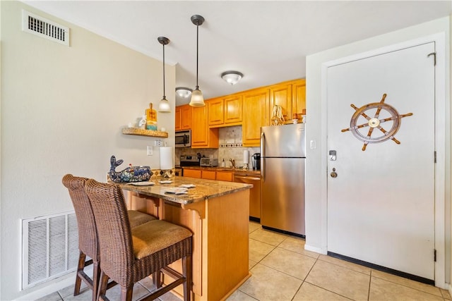 14514 E Cabana St, Corpus Christi, TX 78418 - kitchen featuring stainless steel appliances, a peninsula, a kitchen bar, tasteful backsplash, and light tile patterned floors