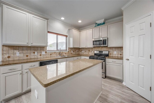 7706 Fort Griffen Dr, Corpus Christi, TX 78414 - kitchen featuring stainless steel appliances, a sink, crown molding, a center island, and light stone countertops