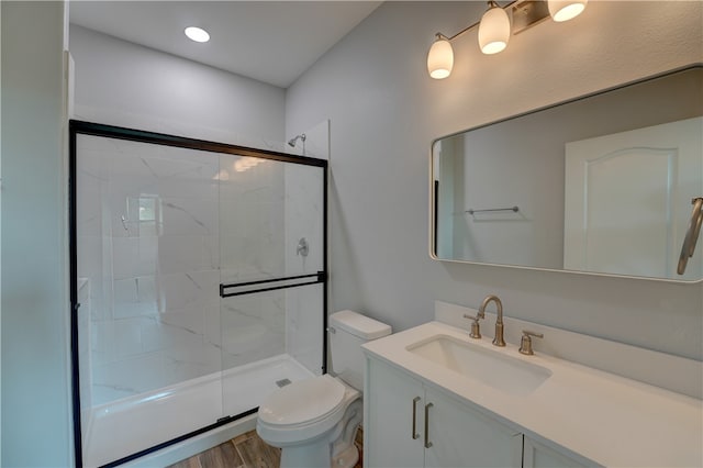 bathroom featuring walk in shower, wood-type flooring, vanity, and toilet