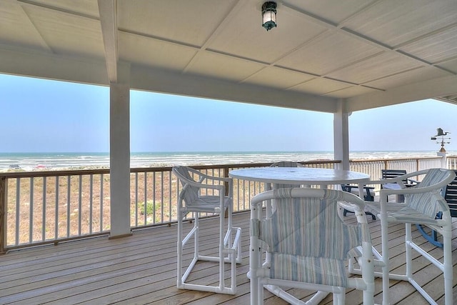 wooden deck featuring a water view and a view of the beach