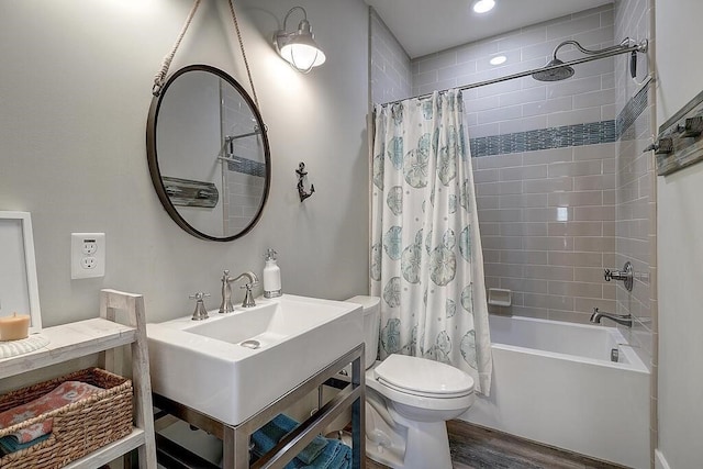 bathroom with hardwood / wood-style floors, toilet, and shower / bath combo with shower curtain